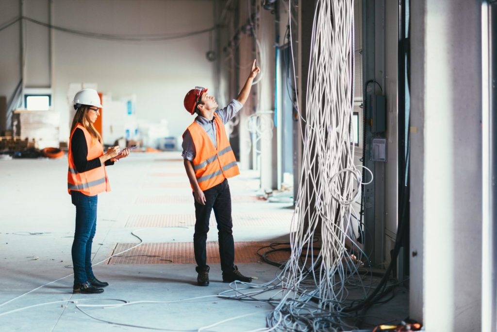 Engineers inspecting electrical cabling during a commercial installation project