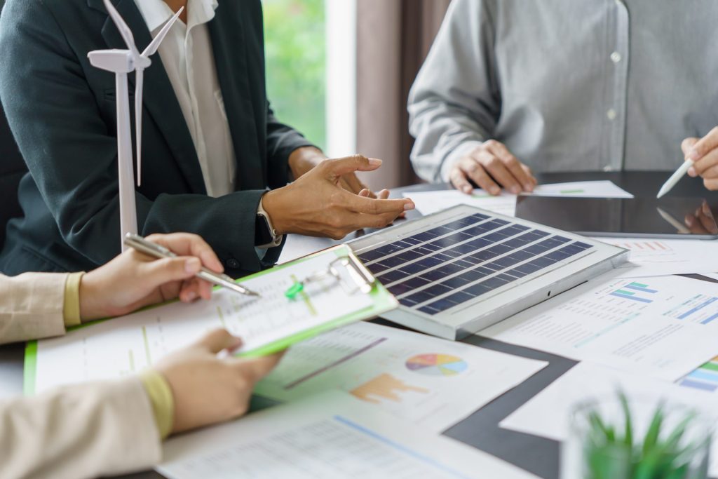 Energy consultants reviewing solar energy data and sustainability reports for a business