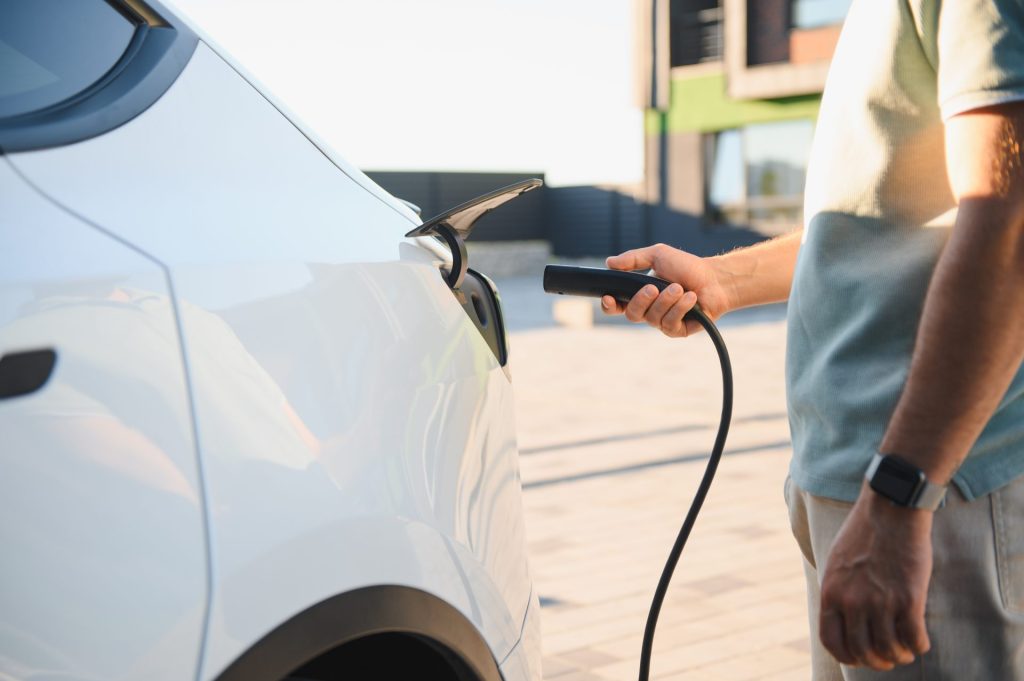 Close-up of EV charging connector plugged into electric vehicle charging port