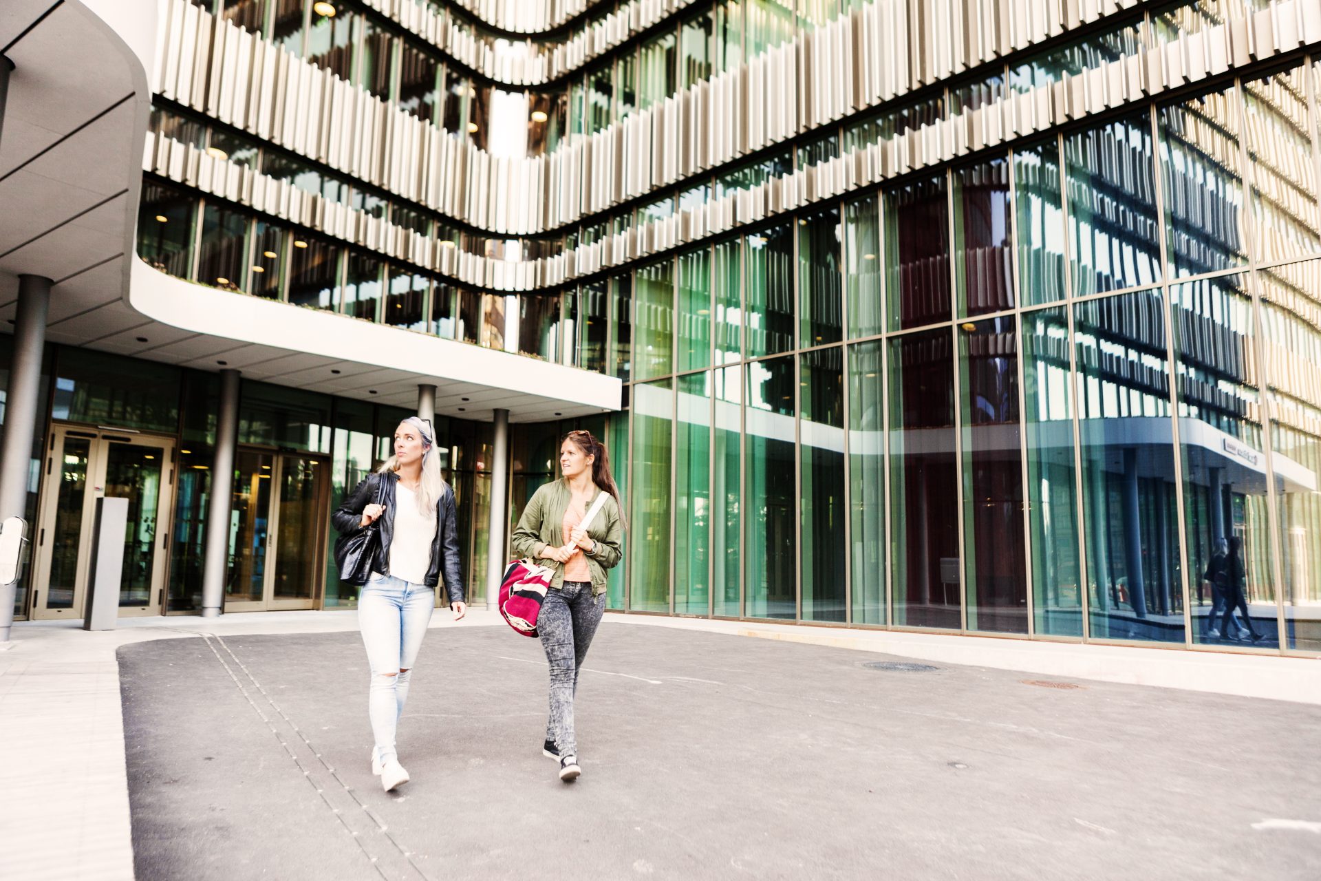 Modern university or public sector building exterior with students walking